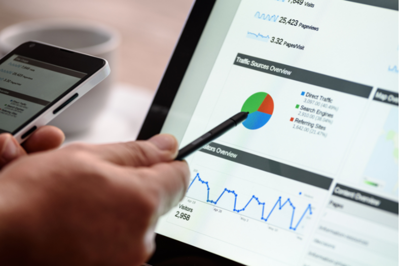 Man points pen at the screen display google analytics page showing website traffic sources