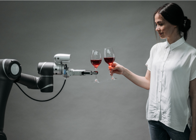 Woman in white shirt interacting with a robotic arm that's holding a glass of red wine, symbolizing the relationship between humans and AI technology as Google's new AI search features transform how businesses connect with customers